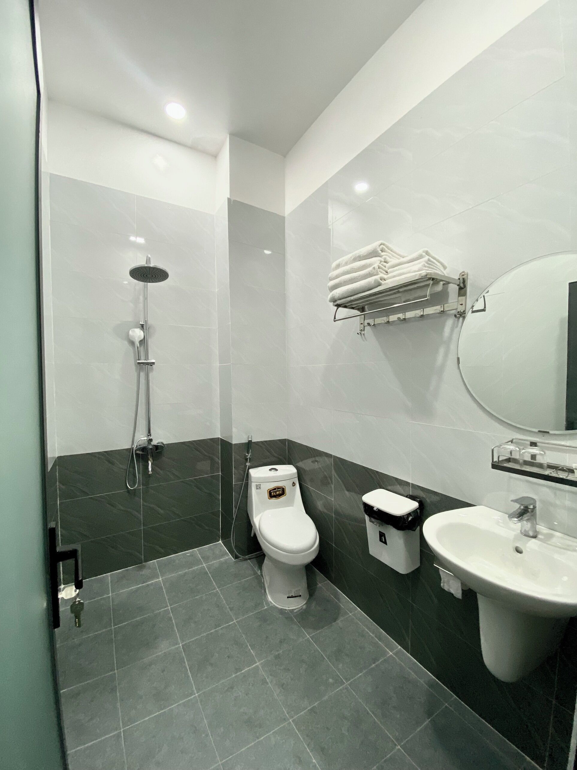 Une salle de bain moderne équipée de toilettes, d’un lavabo et d’une douche.