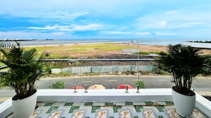 A balcony with a view of a beach and a road. - Seaside Hotel (Rach Gia)