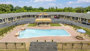 Un hôtel doté d’une piscine, d’un espace extérieur aménagé et d’un patio couvert.
