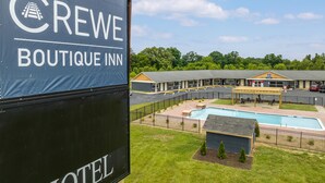 Une enseigne d’hôtel indiquant la présence d’une piscine et d’un espace extérieur aménagé avec des sièges.