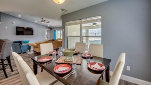 A dining area with a dark wooden table set for four, surrounded by chairs. - Villa Greene, Private Home, Elec. Heated Pool, WIFI, ..... (Cape Coral)