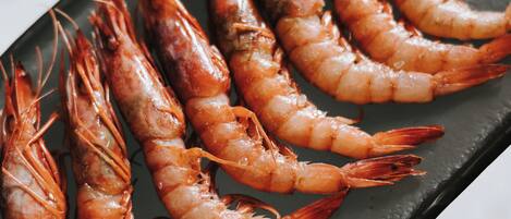 Un plato negro con camarones cocidos.