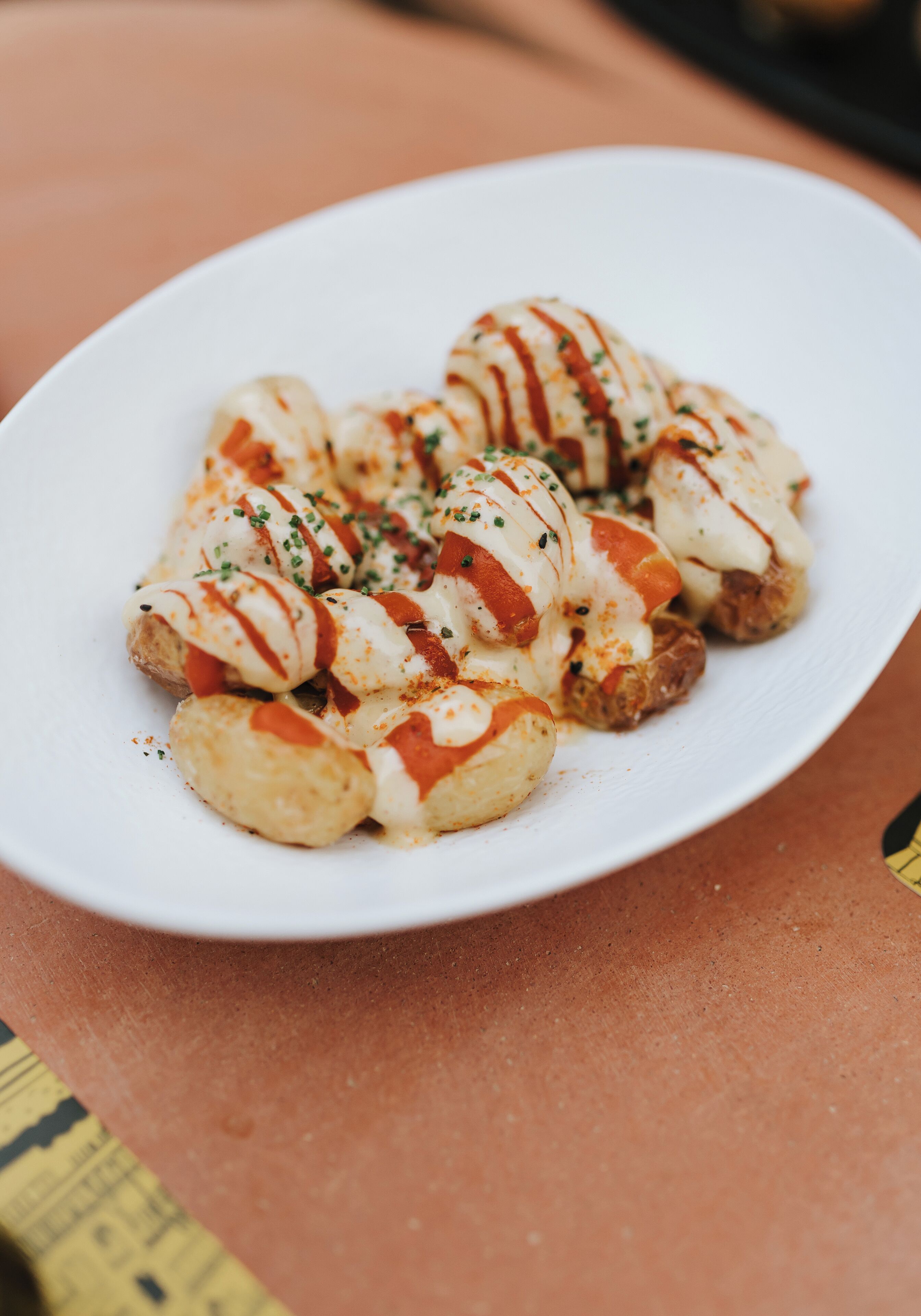 A white plate with food items, possibly appetizers, on a table.