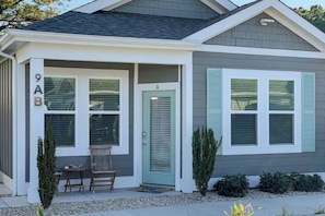 A two-story house with a front porch, a mailbox, and a number '9AB' on the side.