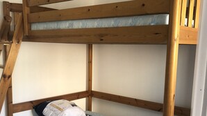 Ein Stockbett mit Holzbettgestell und Matratze.