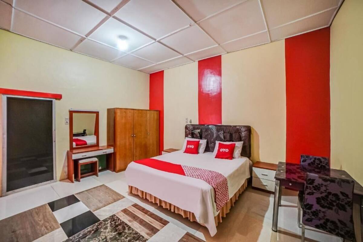 Ein Schlafzimmer mit einem Bett, einem Schreibtisch, einem Stuhl und einem Kleiderschrank.