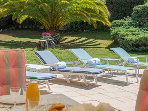Relax in a serene outdoor setting with comfortable lounge chairs and a tranquil garden view.