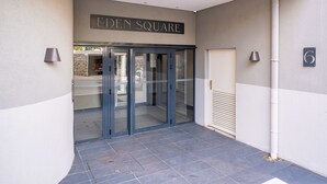 Der Eingang zum Eden Square mit Glastür und einem Schild darüber.