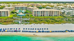 A coastal resort with multiple buildings, a beach with umbrellas, and clear turquoise waters. - HP 45W What the Heck @ High Pointe | Lagoon Pool | Tennis & Pickleball Courts (High Pointe Resort)