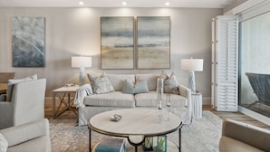 A modern living room with a sofa, two side tables with lamps, a coffee table, and abstract wall art. - HP 45W What the Heck @ High Pointe | Lagoon Pool | Tennis & Pickleball Courts (High Pointe Resort)