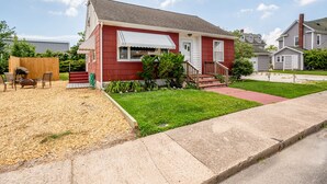 A single-story house with a red exterior and a white front porch.