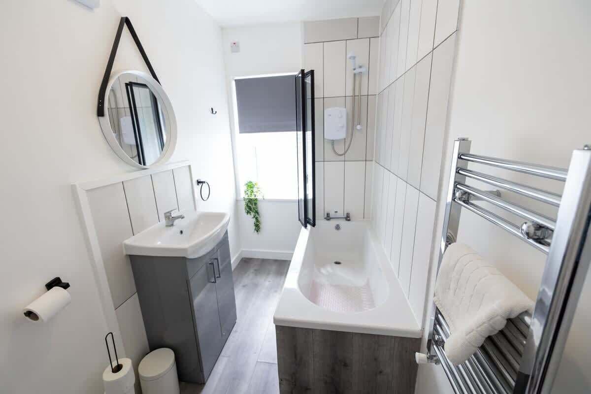 Bathtub, hair dryer, towels, shampoo