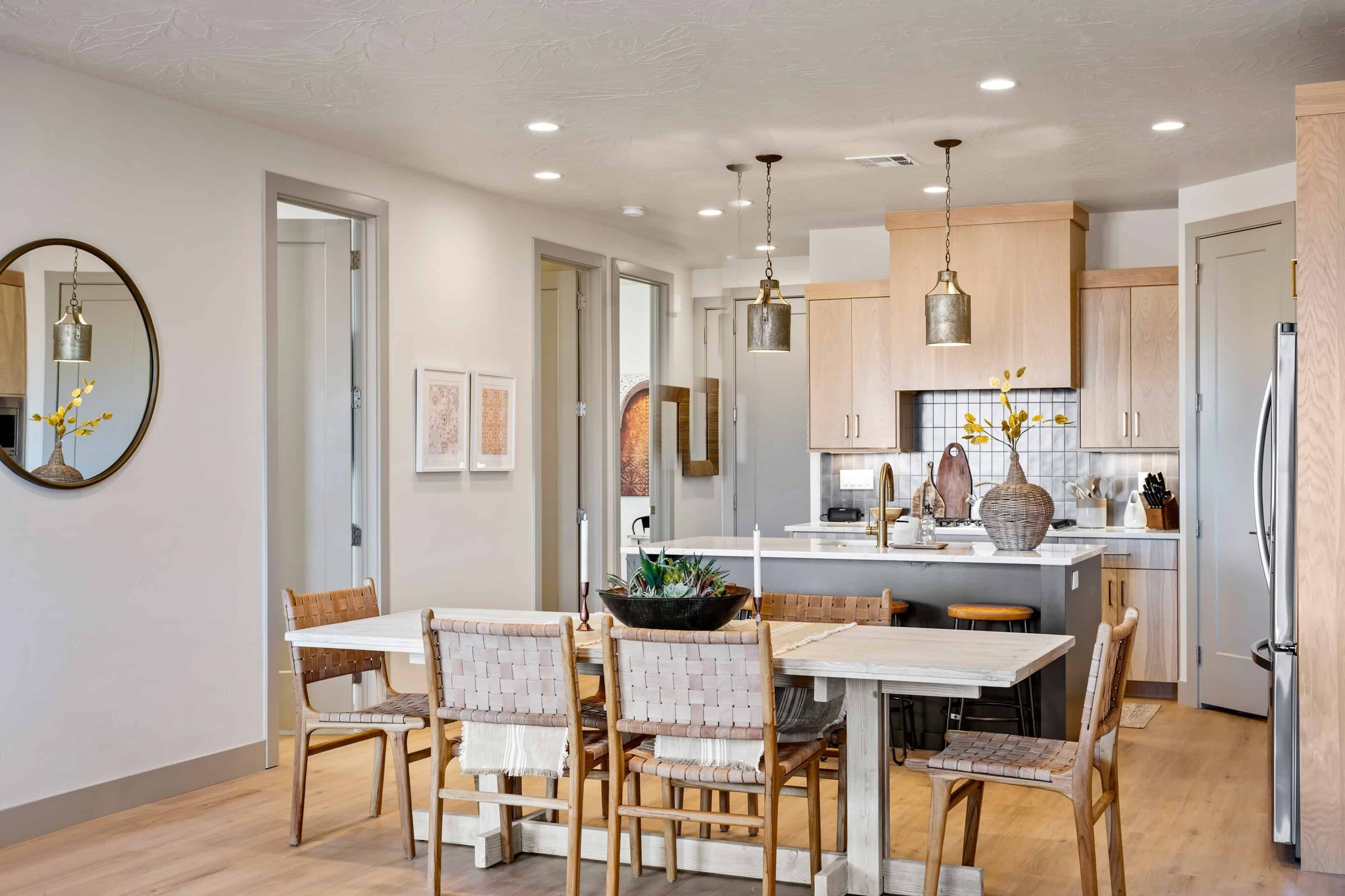 A modern kitchen with wooden cabinets, a central island, and pendant lighting.