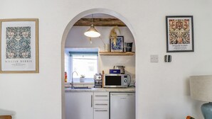 A kitchen with white cabinets, a microwave, a dishwasher, and a hanging pendant light. - 4 Pulmans Place (Halifax)