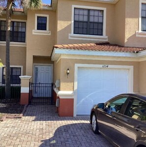 Two-story residence with a garage and entrance.