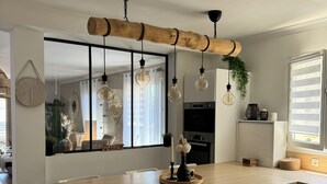 Een moderne keuken met een centraal eiland, hanglampen en een groot raam.