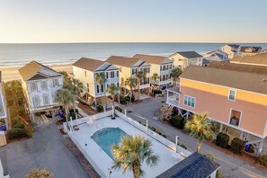 A beachfront residential area with multiple houses, a swimming pool, and a view of the ocean. - Southern Belle: Oceanfront | Surfside Beach Vacation Rental (Surfside Beach)
