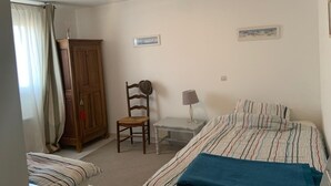 Une chambre à coucher avec un lit, une chaise, un bureau et une armoire.