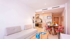 Un salon moderne comprenant un canapé, une table basse et un coin repas avec des chaises et une table.