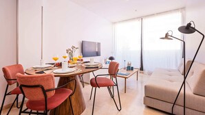 Un salon moderne comprenant un coin repas, un canapé et un téléviseur.