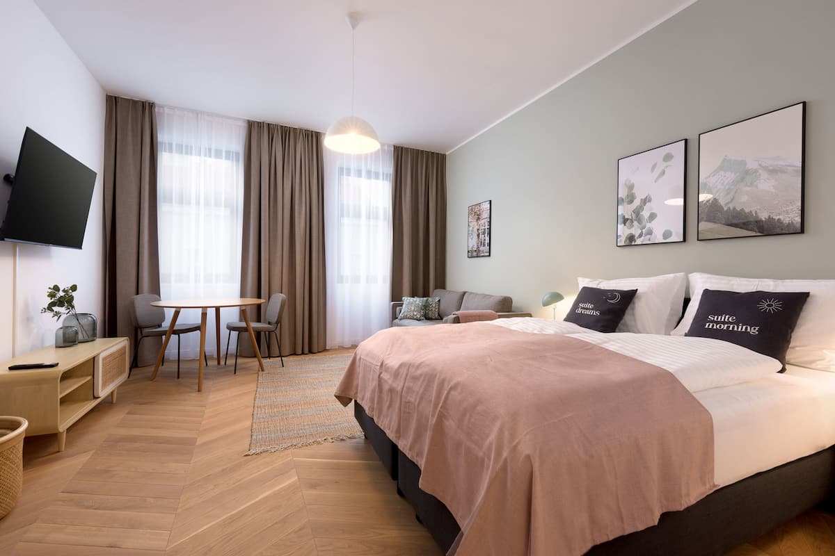 Une chambre d’hôtel moderne équipée d’un grand lit, d’un bureau, d’une chaise et d’un téléviseur.