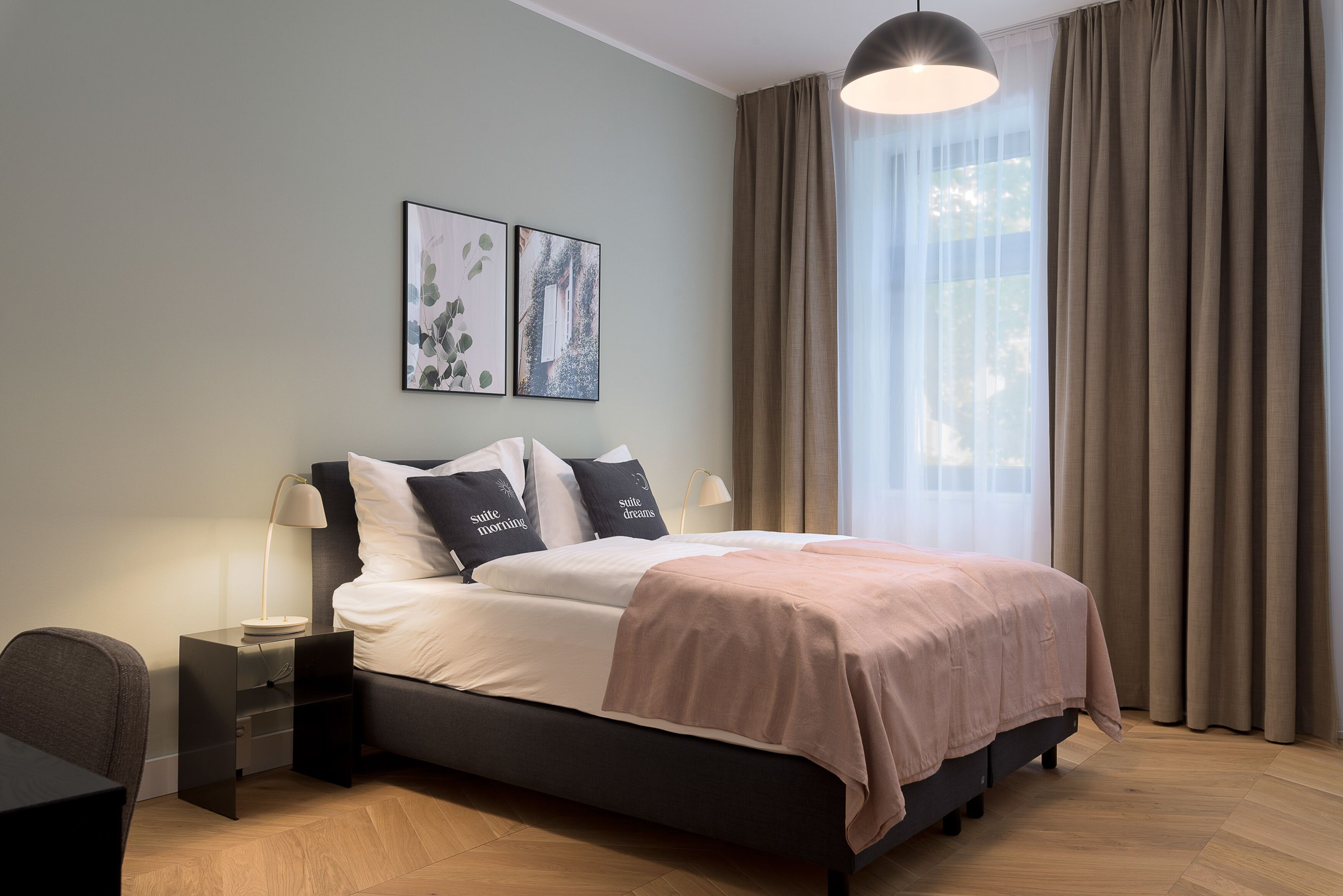 A modern bedroom with a bed, bedside tables, and a window with curtains.