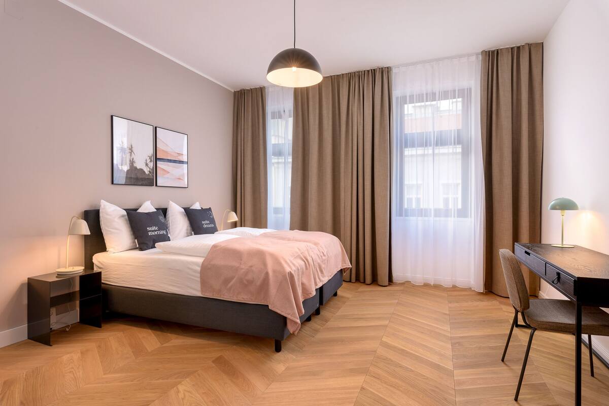 Une chambre à coucher moderne, avec un lit, des tables de chevet, un bureau et une chaise.