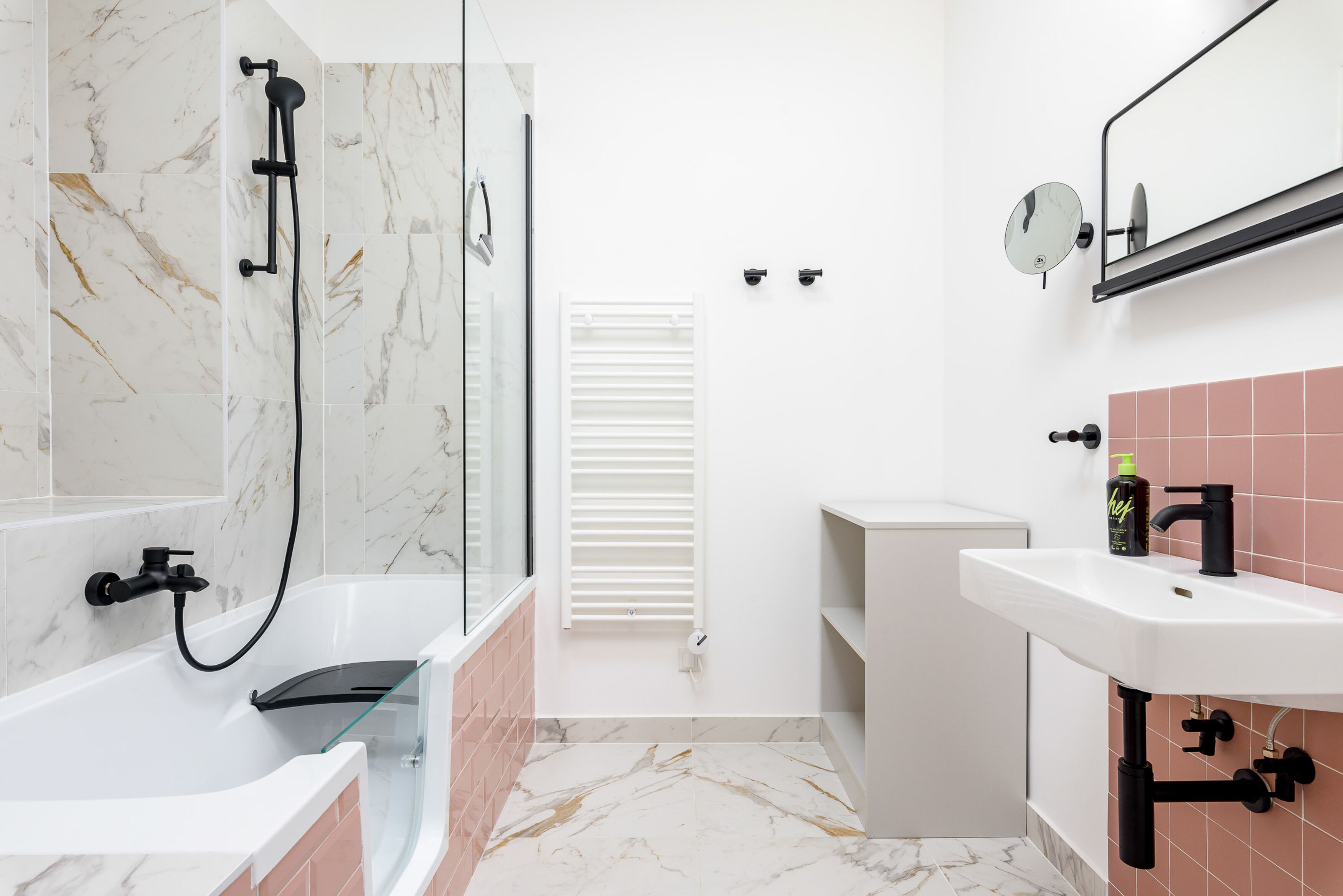 A modern bathroom with a glass-enclosed shower, a white sink, and a mirror above the sink.