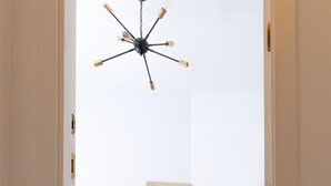 A bedroom with a bed, a mirror, a dresser, and a chandelier. - Figueres Center A 4-minute walk from the Dalí Museum! Spirals Stairs Duplex terrace (Figueres)