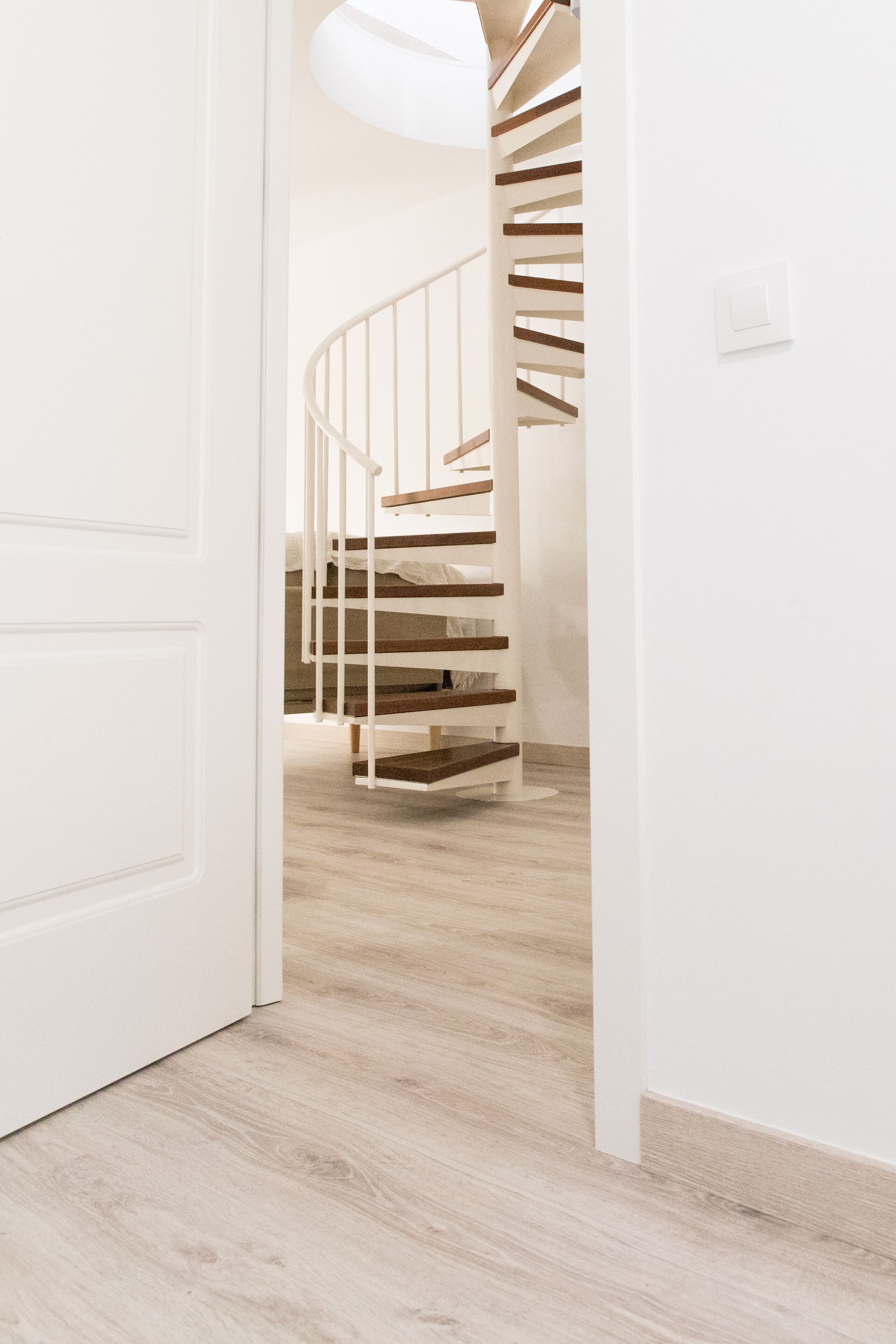 A staircase with wooden steps and metal railings, leading to an upper floor.