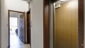 A narrow hallway with wooden doors and a white wall. - Studio Suite With Elevator Near the Old Bridge (Florence)