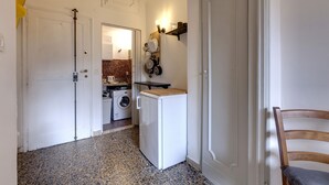 A laundry room with a washing machine, dryer, and ironing board. - Studio Suite With Elevator Near the Old Bridge (Florence)