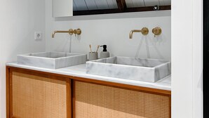 Un baño con dos lavamanos, un espejo grande y un mueble de tocador de madera.