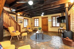 A cozy interior with a staircase, wooden flooring, a fireplace, and a television. - Willunga Cottage- Sleeps 6, Pool (Willunga)