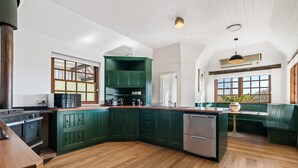 A kitchen with green cabinets, a wooden countertop, a built-in oven, and a dishwasher. - Old Alloway House - Sleeps 11 - Farm Stay (Eglinton)