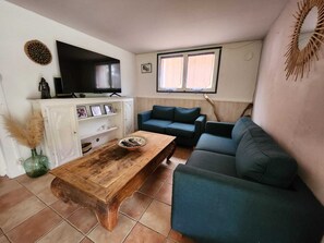 A living room with a TV, sofa, and coffee table.
