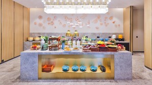 Une cuisine moderne dotée d’un îlot central, d’œuvres d’art décoratives sur les murs et d’un lustre.