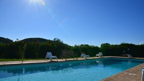 A clear blue sky, a swimming pool with lounge chairs, and a wooden deck. - Villa with pool in Capalbio 6 rooms 6 bathrooms immersed in olive grove (Toscana)