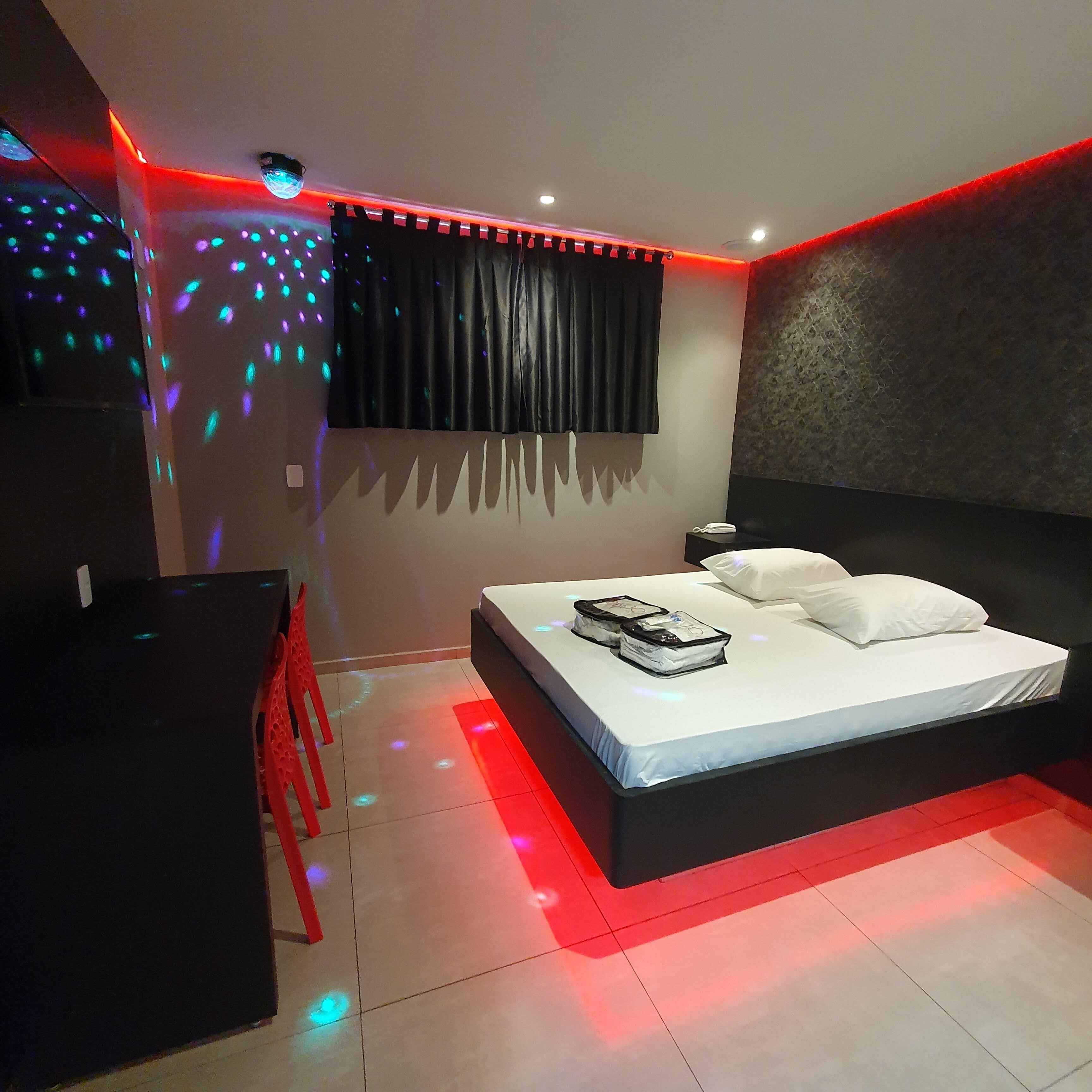 A modern bedroom with a bed, a desk, and a chair.