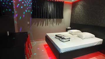 A modern bedroom with a bed, a desk, and a chair.