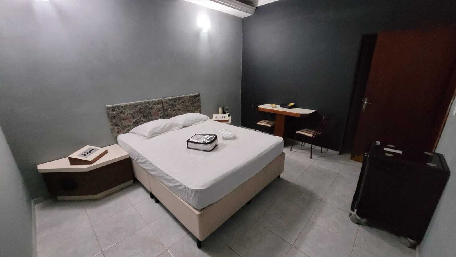 Un dormitorio con cama, mesita de noche, silla, escritorio y armario.