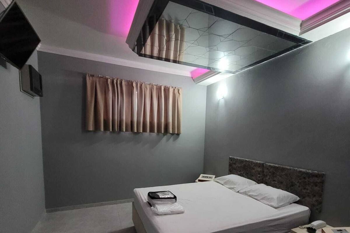 Ein Hotelzimmer mit einem Bett, einem Nachttisch und einer Deckenleuchte.