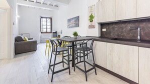 Una cocina moderna con encimera oscura, armarios de madera y una zona con taburetes de bar.
