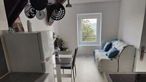 Una cocina compacta con zona de comedor y sofá.