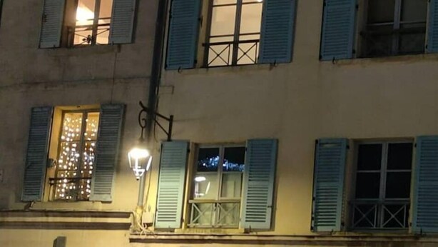Un edificio con un letrero de farmacia, un símbolo de cruz y un cartel en la pared.