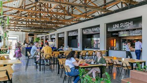 A modern restaurant with exposed wooden beams, multiple seating areas, and a sushi bar. - WI-FI 200MB | Me2 Benefits | Foodhall #TS1 (Florianópolis)