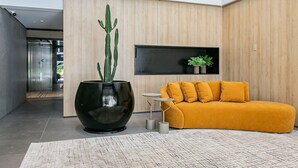 A modern interior with a large black pot, a yellow sofa, and a small table. - WI-FI 200MB | Me2 Benefits | Foodhall #TS1 (Florianópolis)