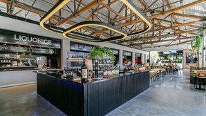 A modern bar area with a central counter, surrounded by seating and various food and drink outlets. - WI-FI 200MB | Me2 Benefits | Foodhall #TS1 (Florianópolis)