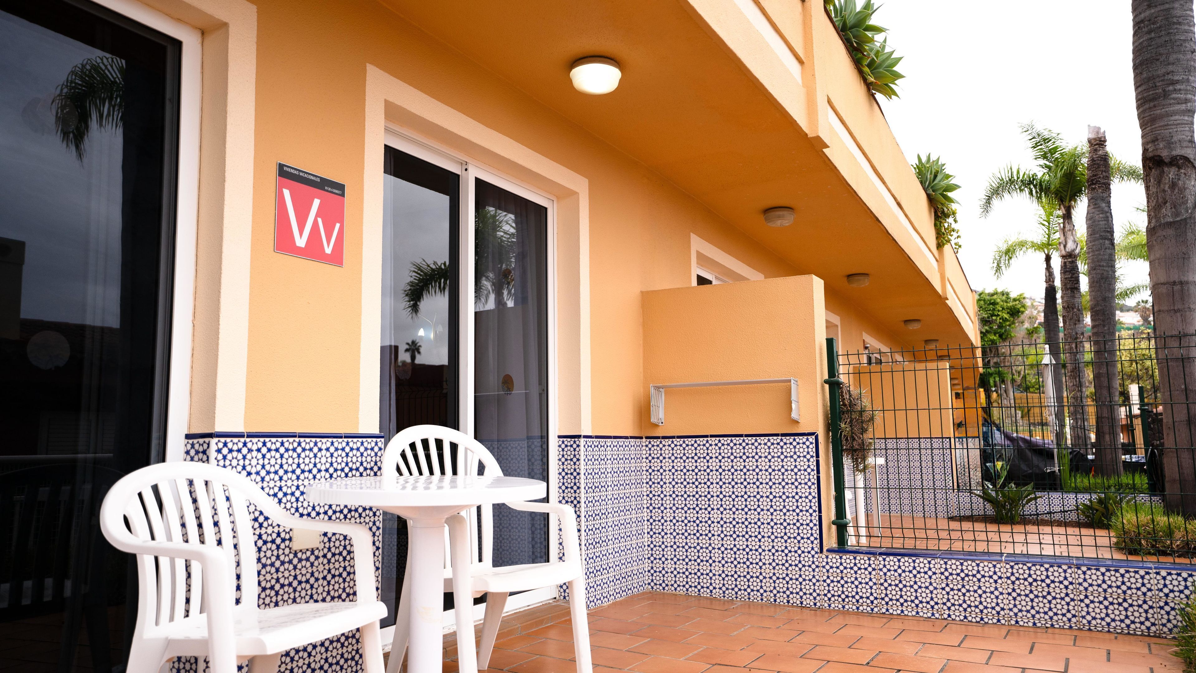 L’entrée d’un hôtel, avec un mur recouvert de carreaux, une porte et une enseigne.