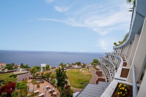 Un complexe hôtelier offrant une vue sur l’océan, doté d’un espace extérieur aménagé et caractérisé par une architecture aux lignes courbes.